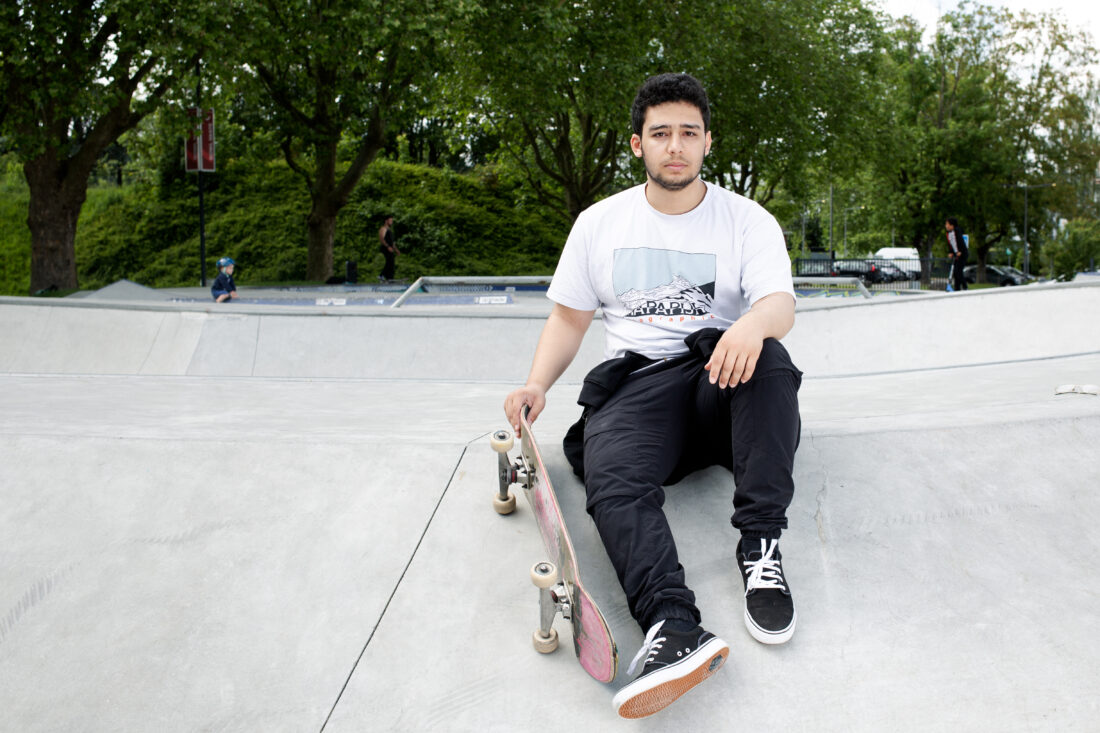 Portrait d'un adolescent posant assis sur une structure de ciment gris avec un skateboard (planche à roulettes) à la main, issu du reportage photographie de Richard Baron (membre de Light Motiv) sur la mobilité urbaine des jeunes à Lille pour le magazine Phosphore, numéro 34, septembre 2024