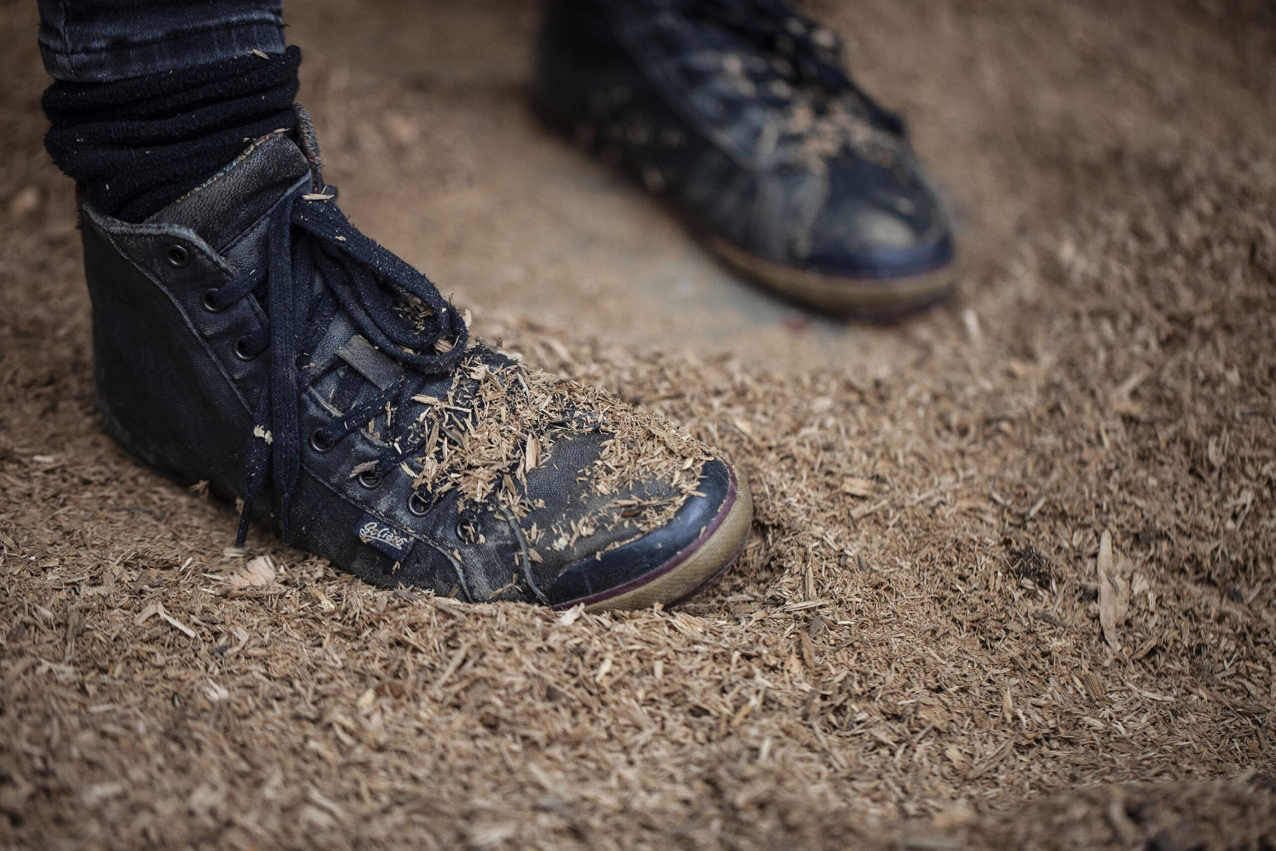 Sciure de bois sur chaussures pendant le tournage, dans l'atelier de Lucille, tourneuse sur bois, à Locre à la frontière belge. Photographie de Nadège Fagoo (Light Motiv)